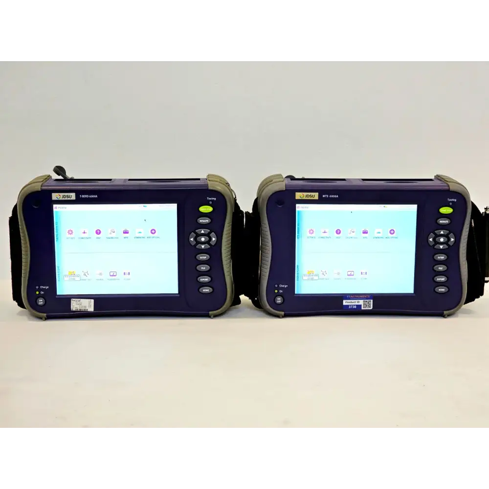 Two Viavi JDSU MTS 6000A V2 OTDR units side by side, both powered on showing Home screen — T-BERD 6000A left, MTS 6000A right