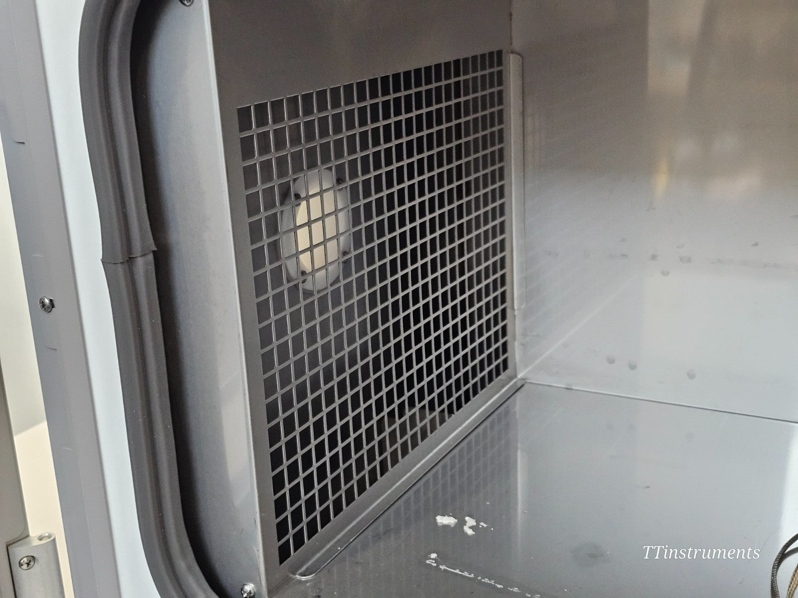 CryoMed TSCM34PV freezer chamber interior side wall with fan guard showing clean stainless steel surfaces and minor residue at base