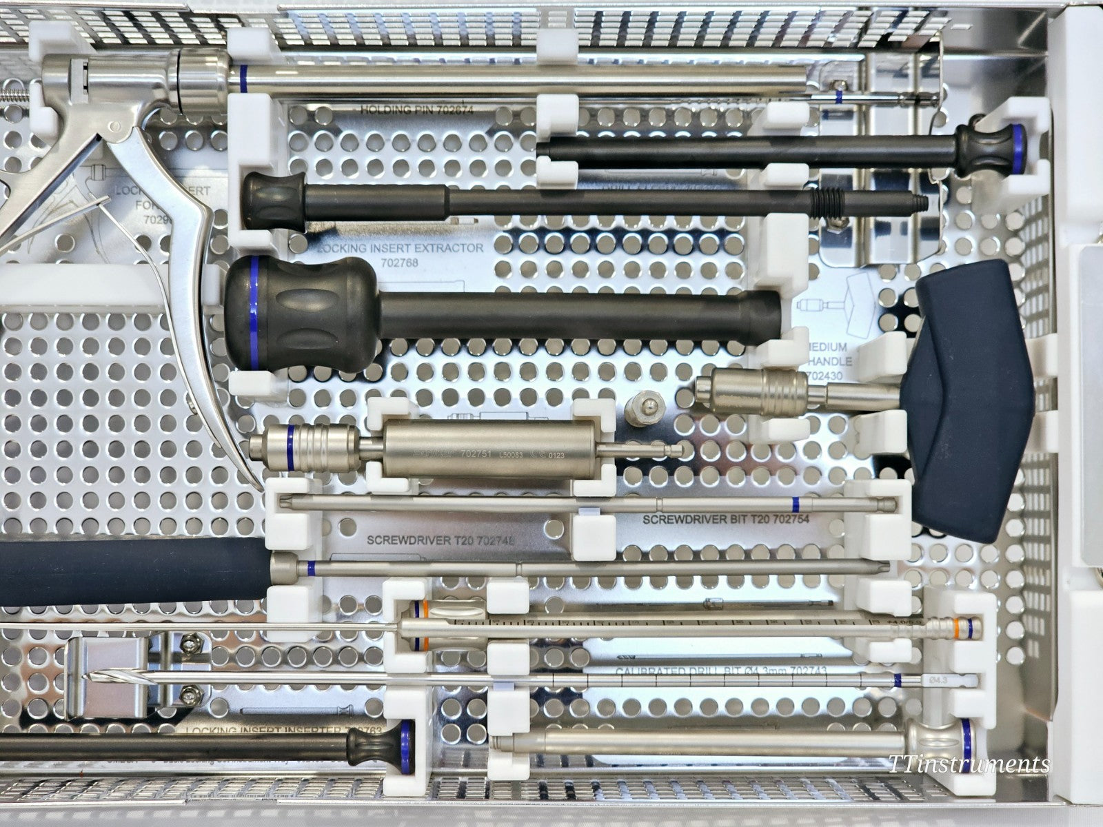 Stryker Omega 3 instrument tray close-up showing holding pin 702674, locking insert extractor 702768, screwdriver T20 and drill bits