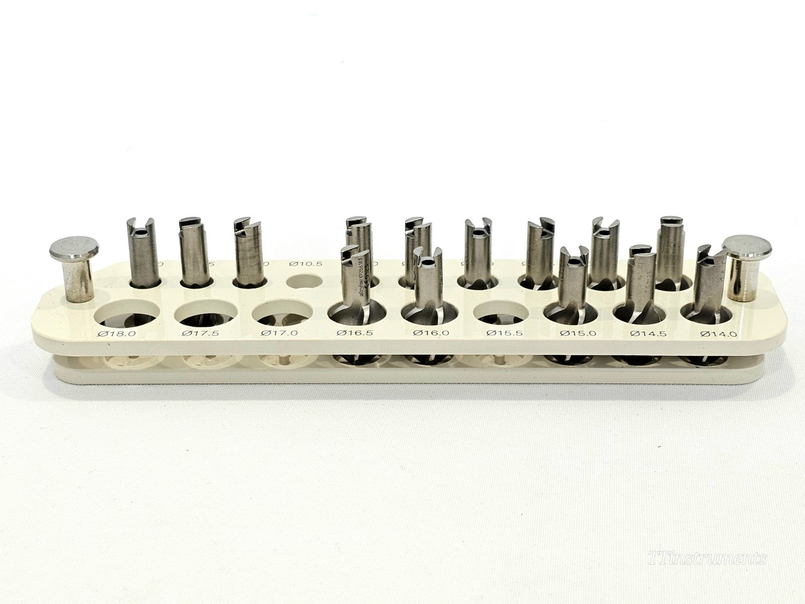 Stryker Bixcut modular reamer head block close-up showing 20 heads sized Ø14.0–Ø18.0mm with slotted cutting faces, in labelled white holder