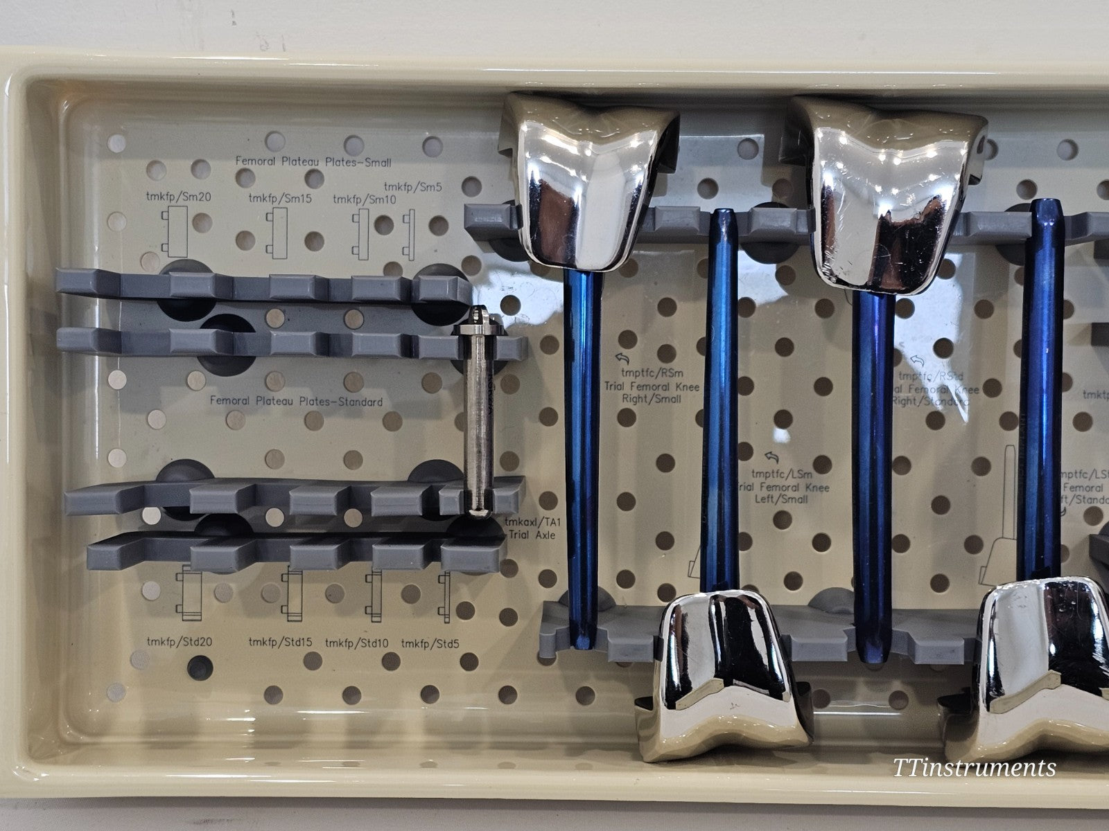 METS SMILES Knee Trial Set lower tray close-up showing femoral plateau plates Small and Standard, trial axle tmkaxl/TA1, and chrome femoral knee trial components