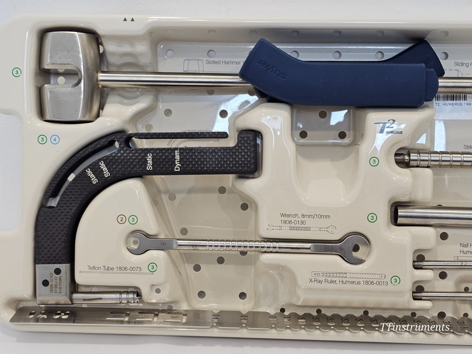 Stryker T2 Humerus Tray 2 close-up — slotted hammer, carbon fibre targeting arm labelled Static/Dynamic, Teflon tube 1806-0073, wrench and x-ray ruler