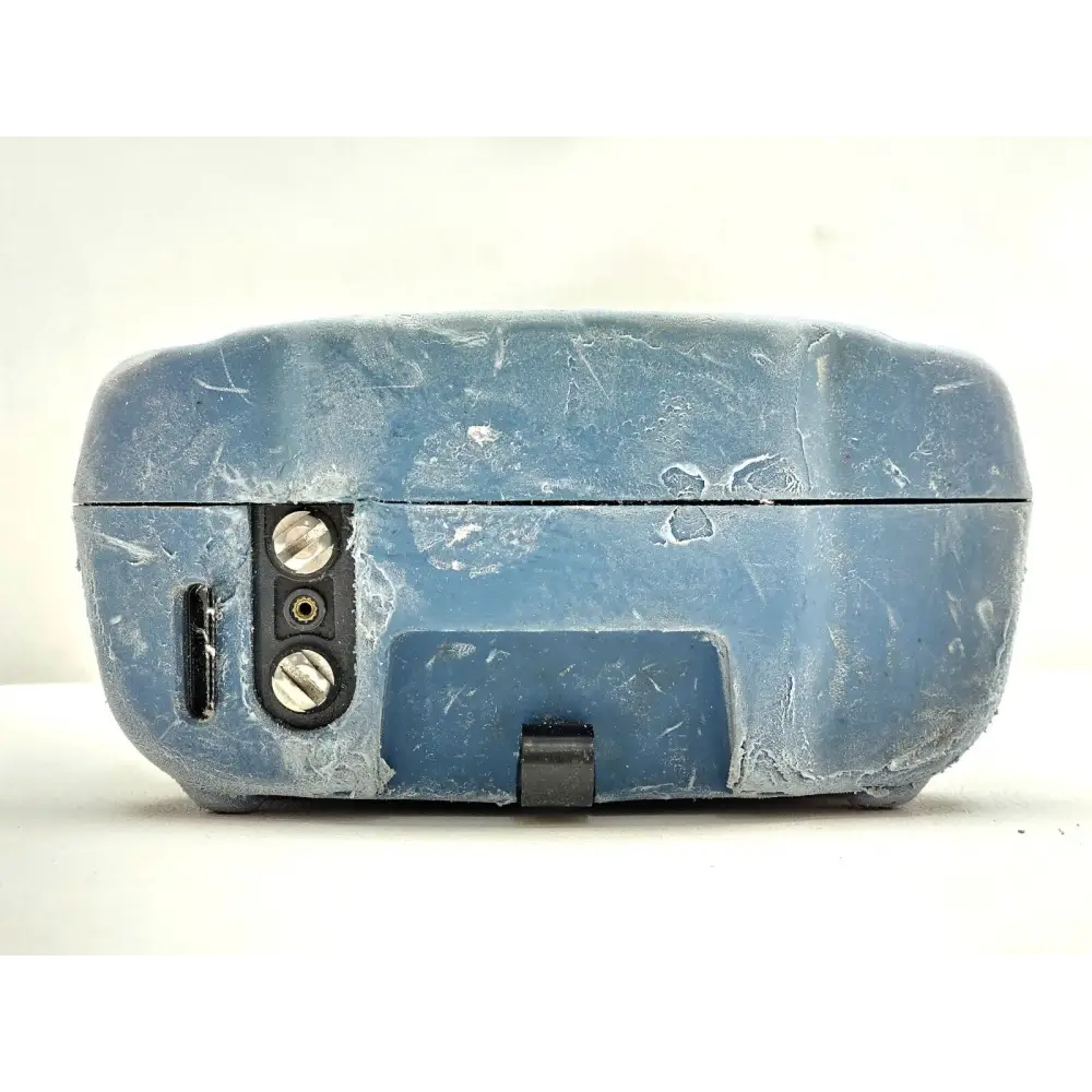 EXFO FTB-200 V2 top panel showing worn blue rubber bumper casing, battery latch and ground terminal