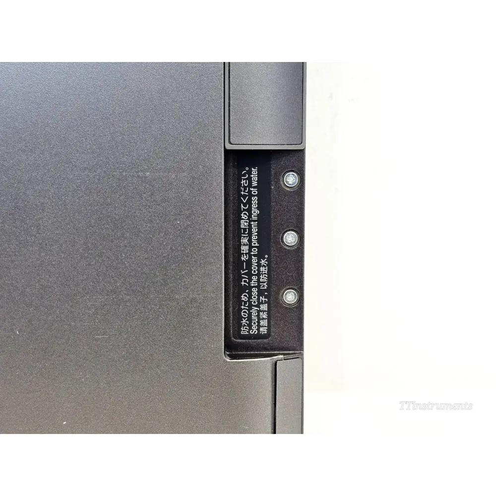 Fujifilm FDR D-EVO III C35i — side edge close-up showing waterproof port cover with multilingual water ingress warning