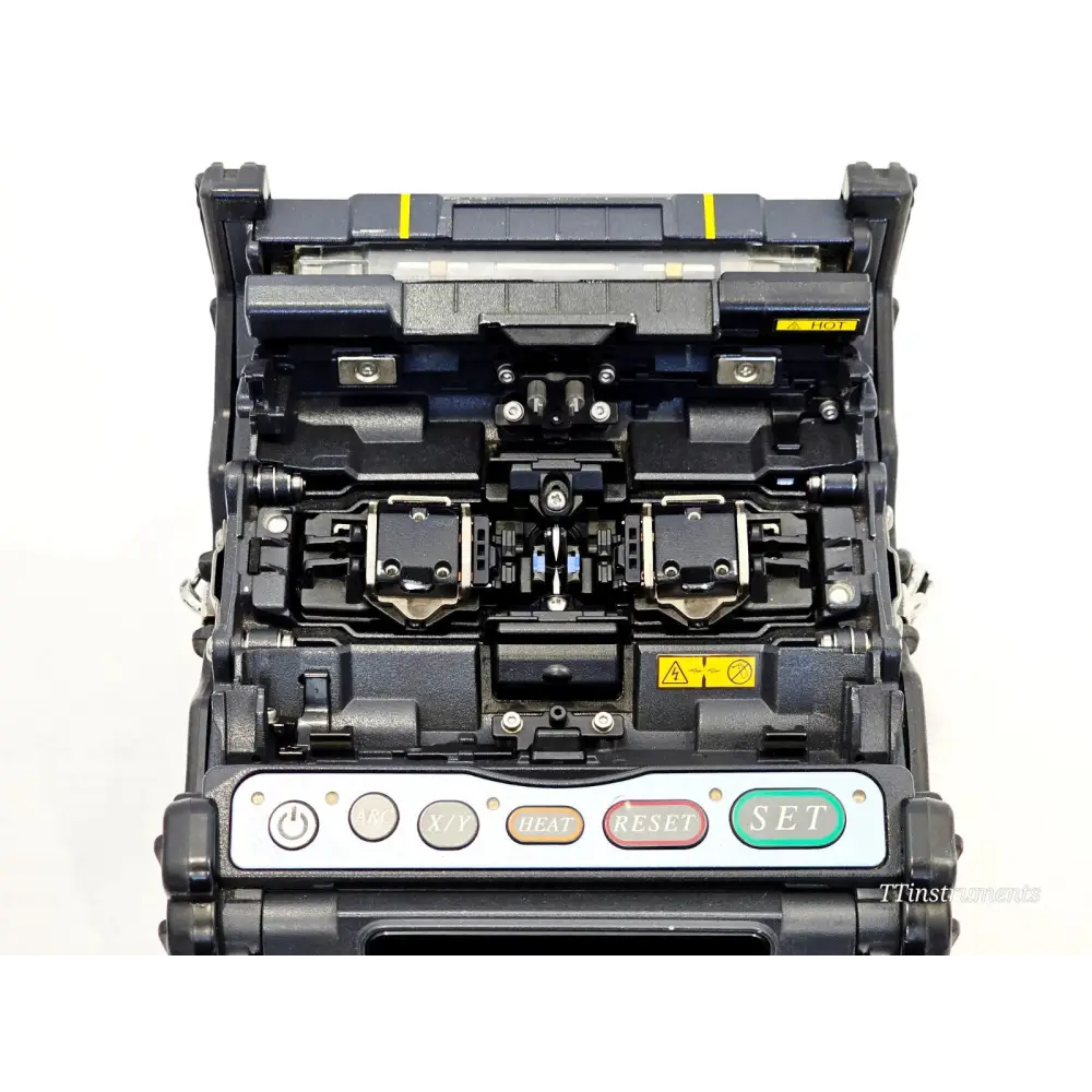 Fujikura FSM-70S top-down view of open splice bay showing V-grooves, fibre clamps, electrodes, and heater tray