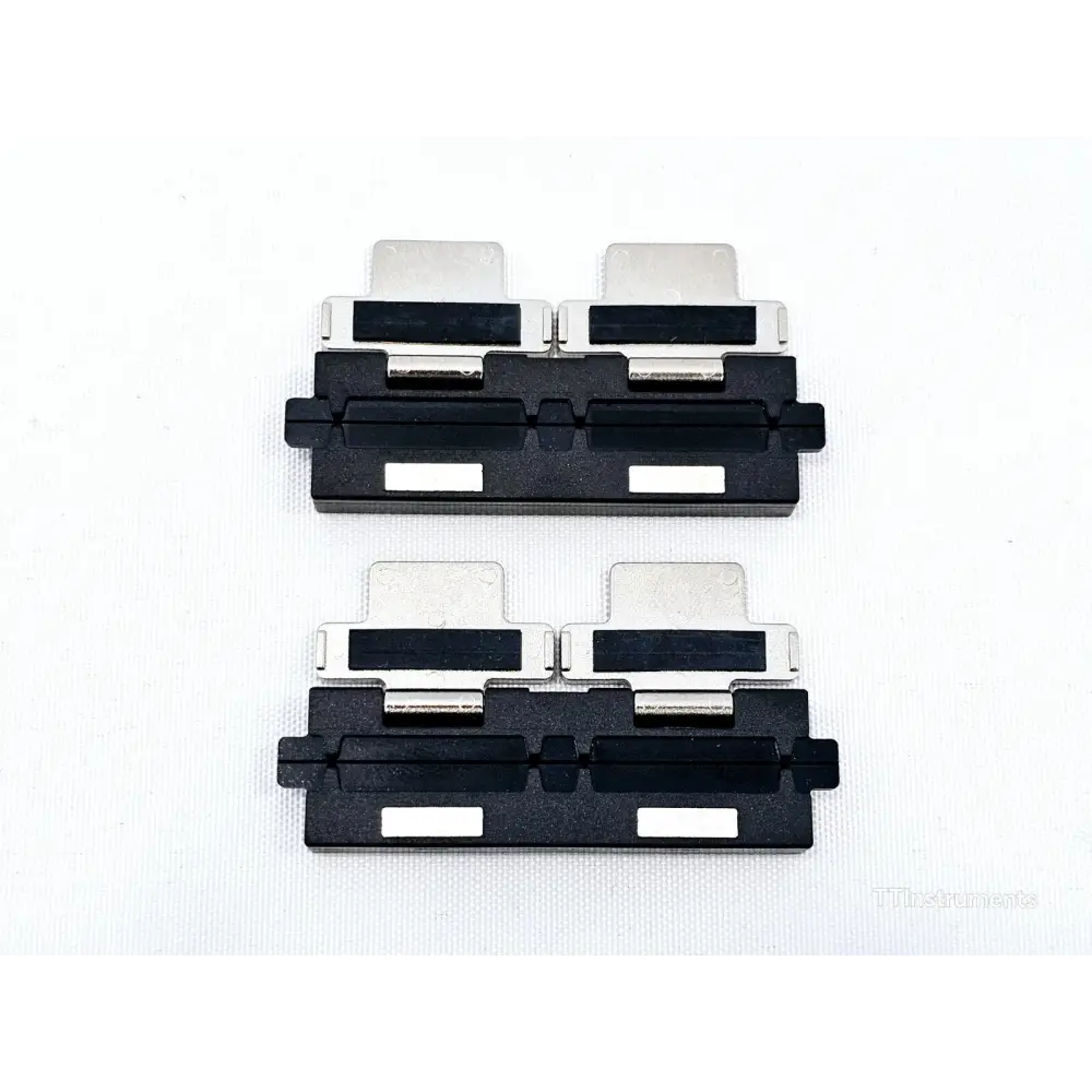 Fujikura FH-250 fibre holder clamp pair — underside view showing V-groove channels and clamping mechanism