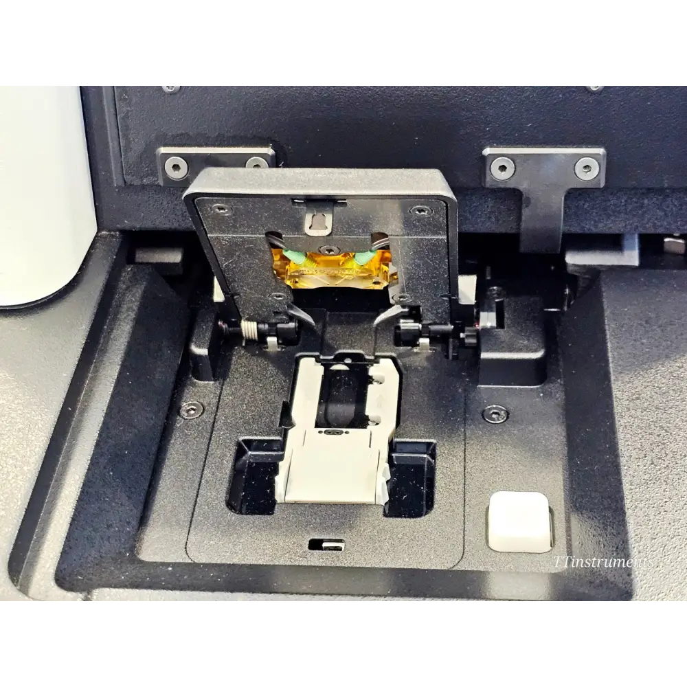 Illumina MiniSeq SY-420-1001 flow cell bay close-up showing objective lens assembly, flow cell holder, and clamp mechanism