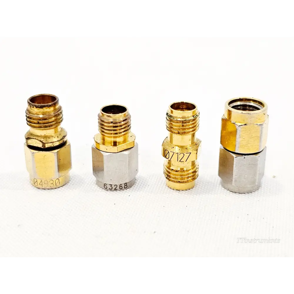 Close-up of four Keysight 11904S 2.4mm to 2.92mm K metrology-grade adapters with serial numbers 04930, 63268, 07127 visible