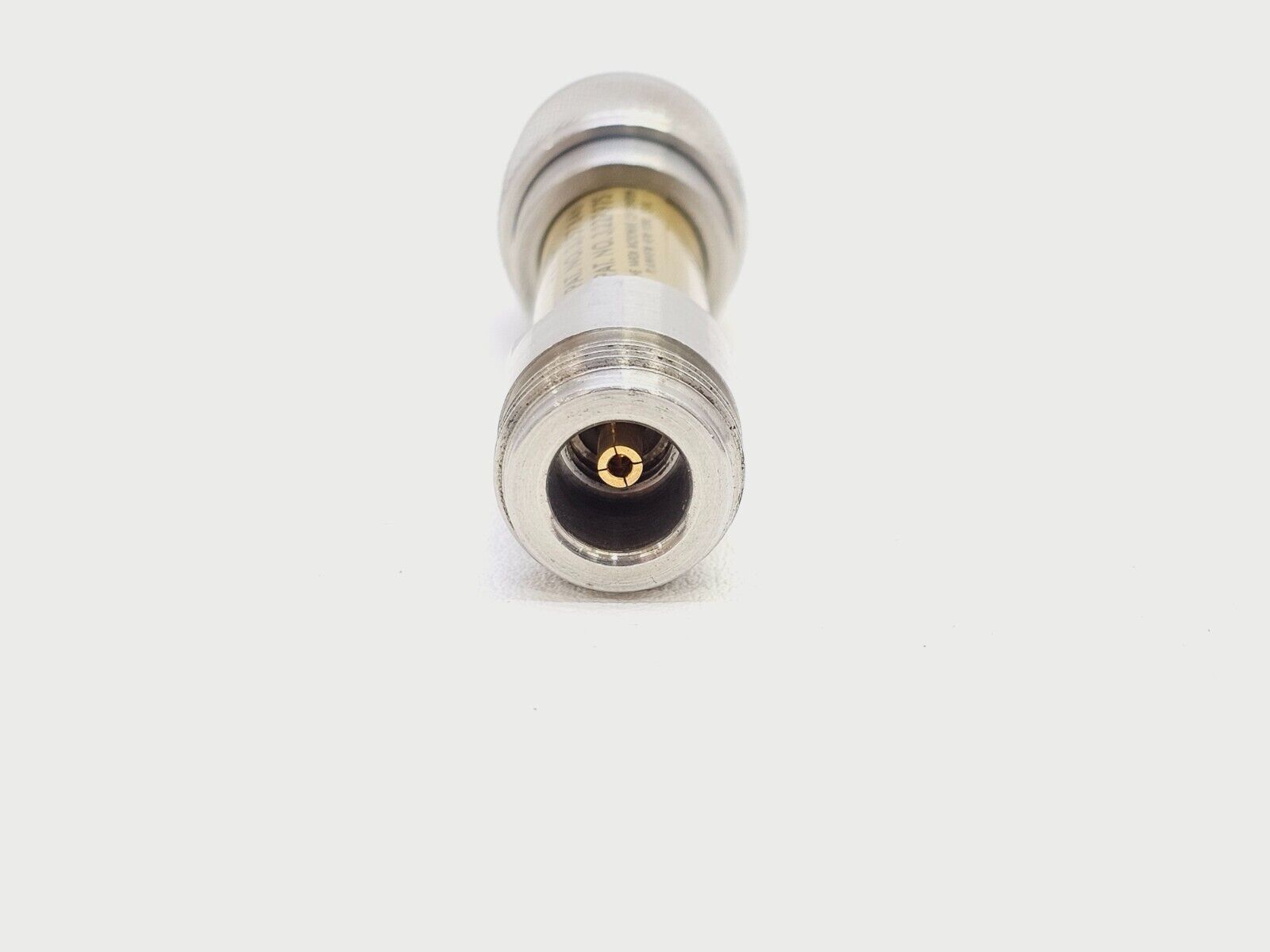 Narda 777C-3 coaxial fixed attenuator angled three-quarter view showing full body and both connector ends
