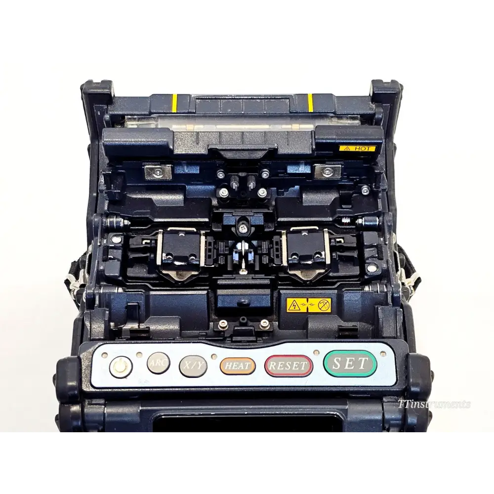 Fujikura FSM-70S fusion splicer top-down view showing open splice deck with V-grooves, electrodes, and clamps