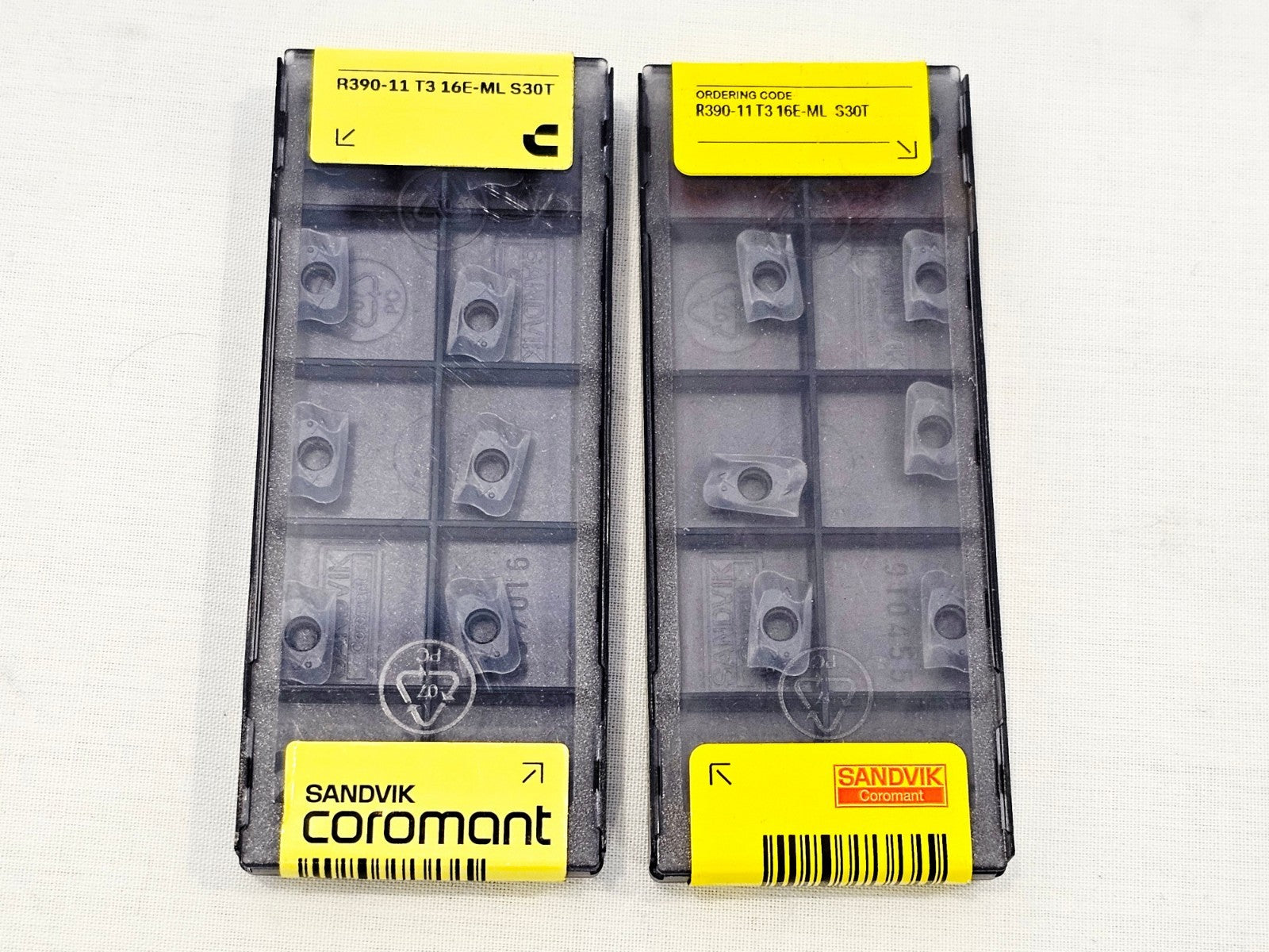 Two sealed Sandvik Coromant R390-11 T3 16E-ML S30T insert packs side by side, yellow labels visible