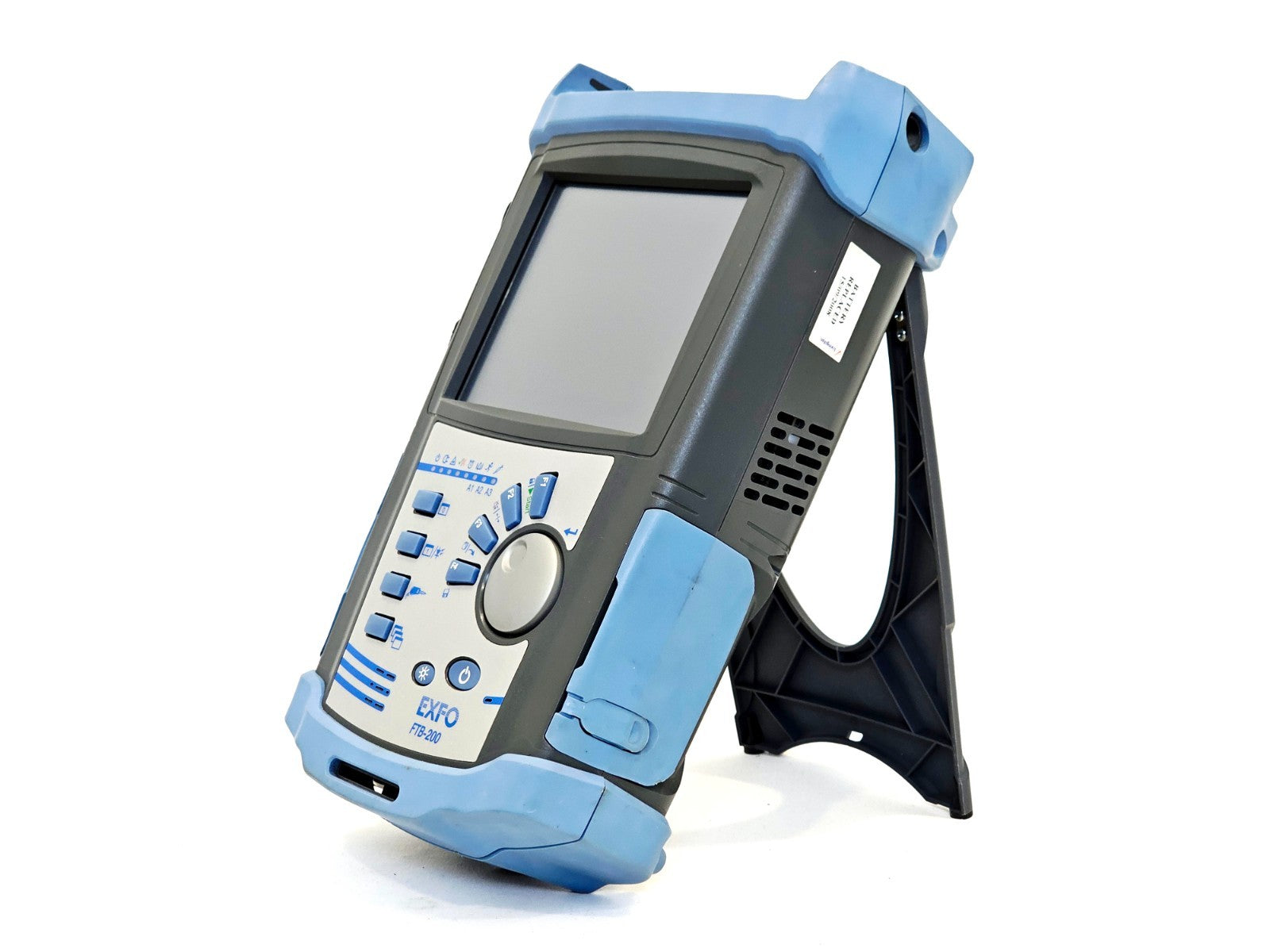 EXFO FTB-200 side-angle view on built-in stand showing right side vents and serial number label