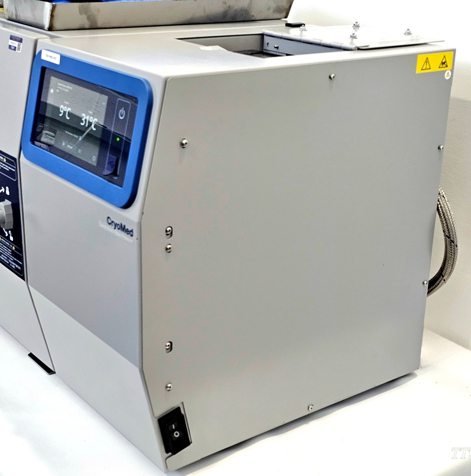 CryoMed TSCM34PV right-side and rear view showing power switch, LN2 braided hose connection and touchscreen displaying 9°C / 31°C