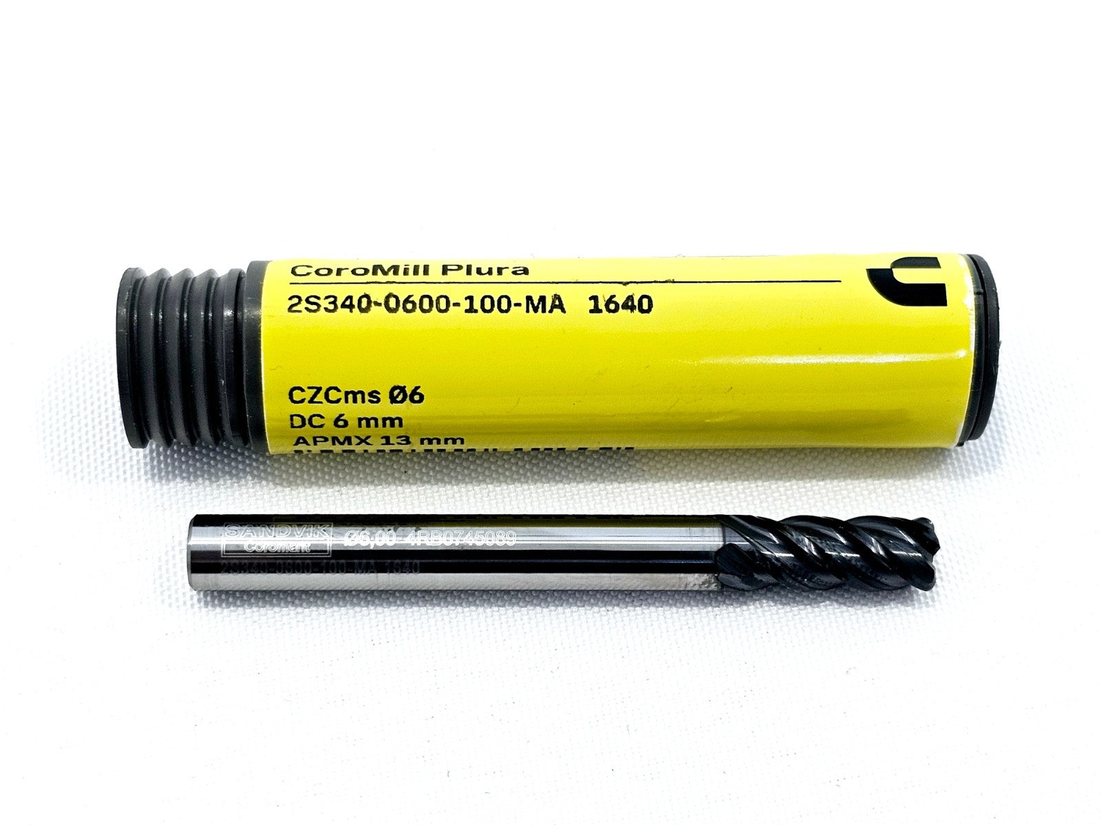 Sandvik Coromant CoroMill Plura 2S340-0600-100-MA 1640 6mm end mill lying beside its yellow specification canister showing 5-flute TiAlN tip