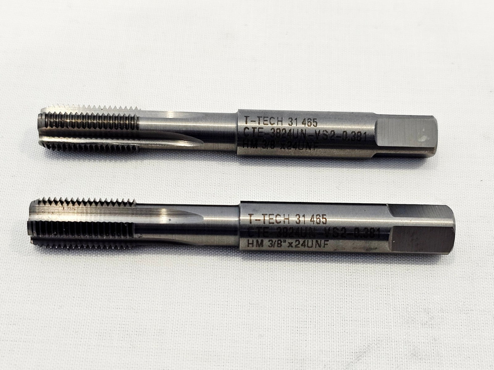 Two T-TECH CTE-3824UN-VS2 left-hand 3/8-24 UNF carbide hardmetal thread taps side by side, showing engraved markings