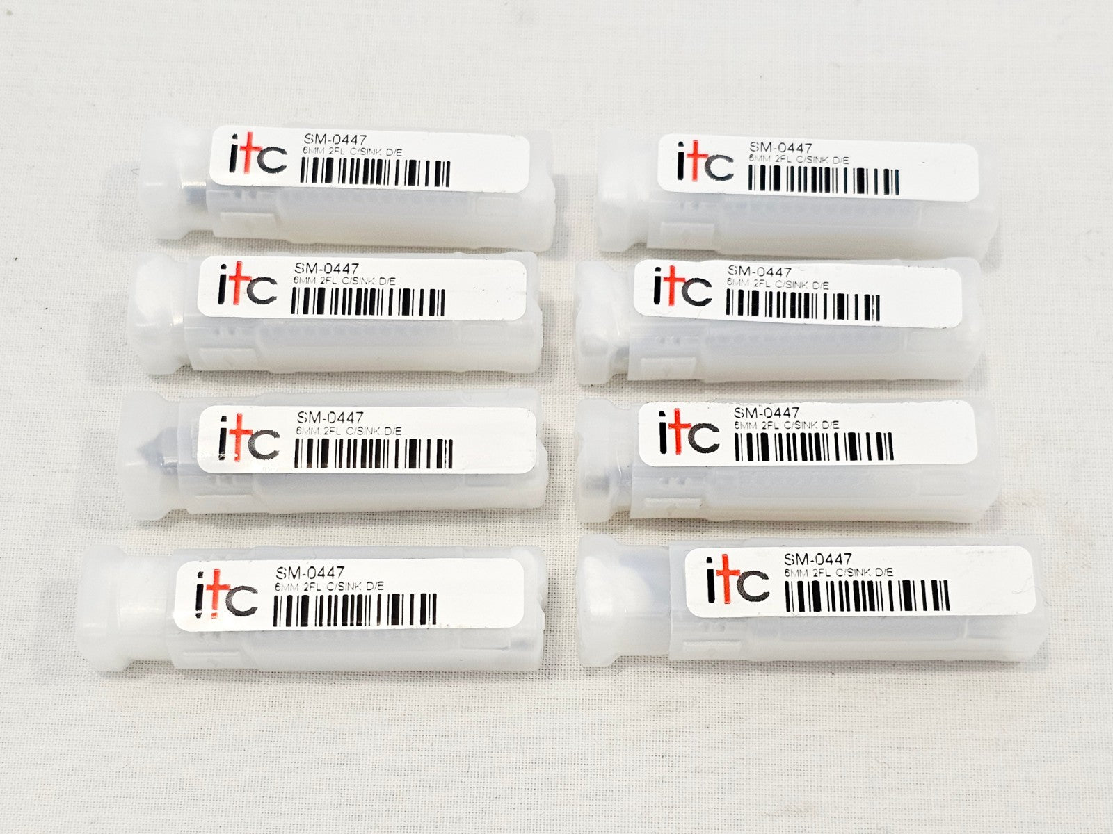 8x ITC SM-0447 6mm 2-flute double-ended countersinks in original plastic storage tubes, top-down view