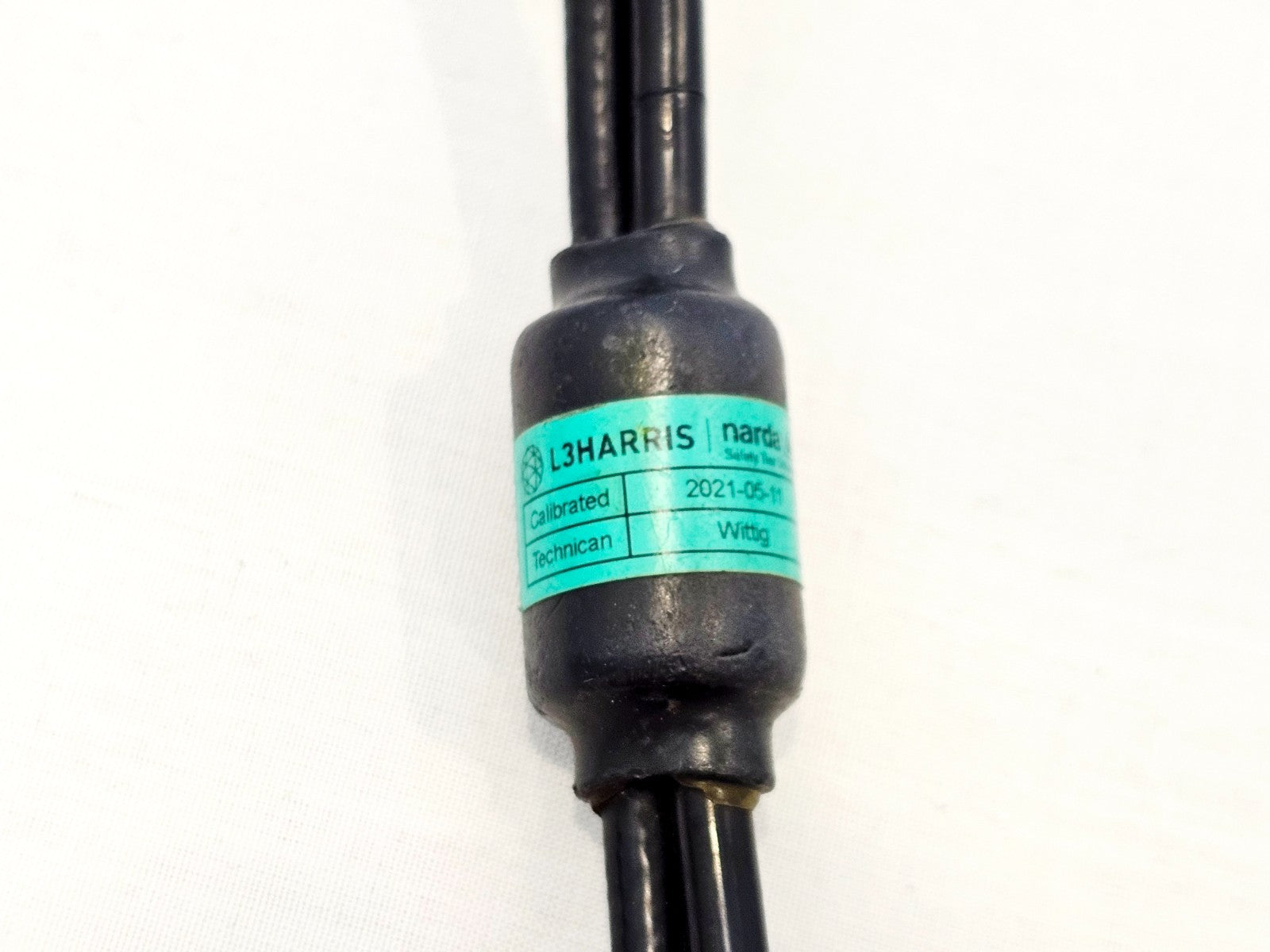 Narda SRM RF cable L3Harris calibration label showing calibration date 2021-05-11 and technician name Wittig