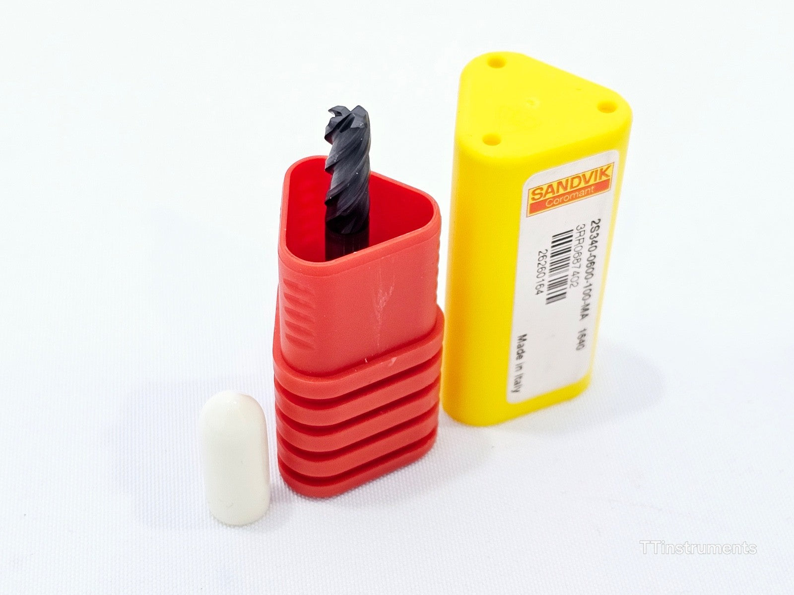 Sandvik CoroMill Plura 2S340-0600-100-MA end mill partly inserted into open red plastic tube with yellow cap and white shank protector