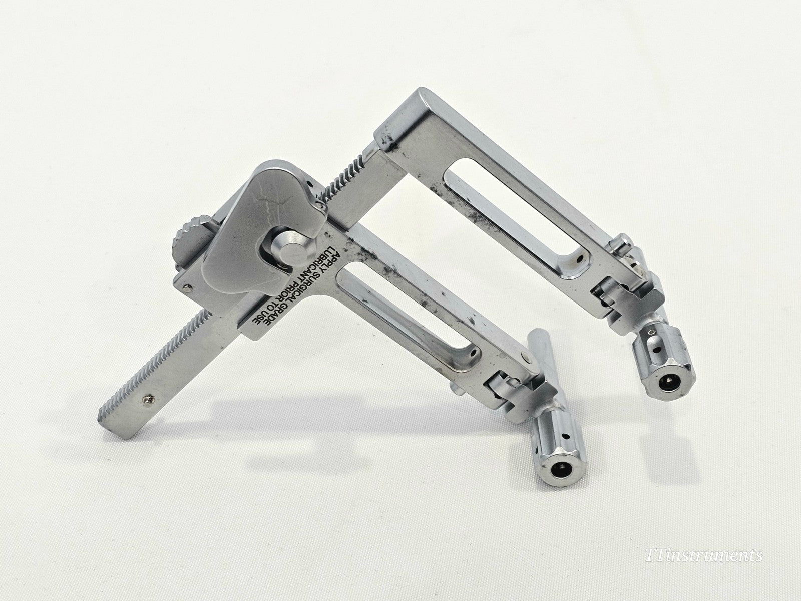 Wright Medical X-Track 5882000X side view showing ratcheted arm, collet adjustment mechanism and lubricant warning label