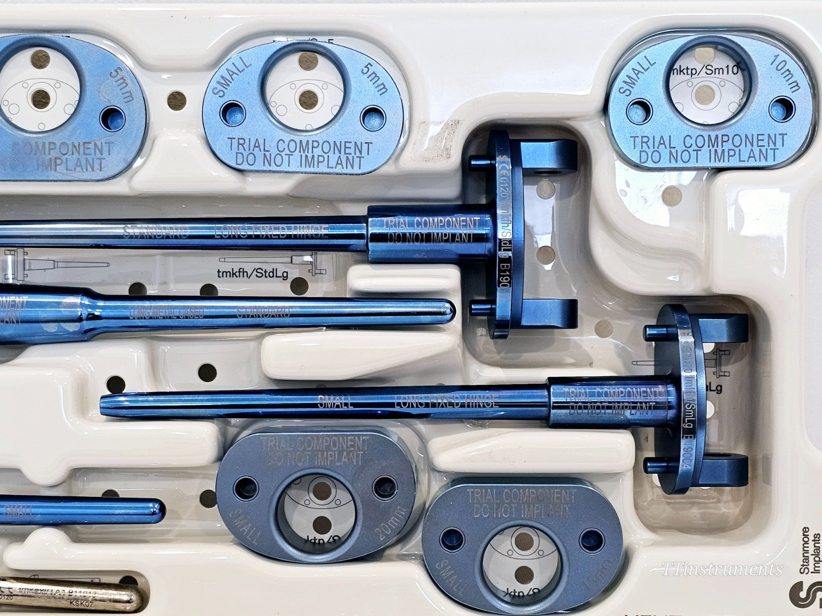 Stanmore METS trial components close-up showing Small and Standard bearing pads 5mm–10mm marked Trial Component Do Not Implant