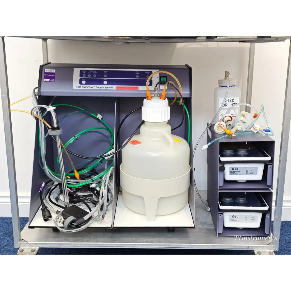 BD FACSCelesta lower shelf showing FACSFlow Supply System, large sheath container, DH2O bottle and BD reagent trays