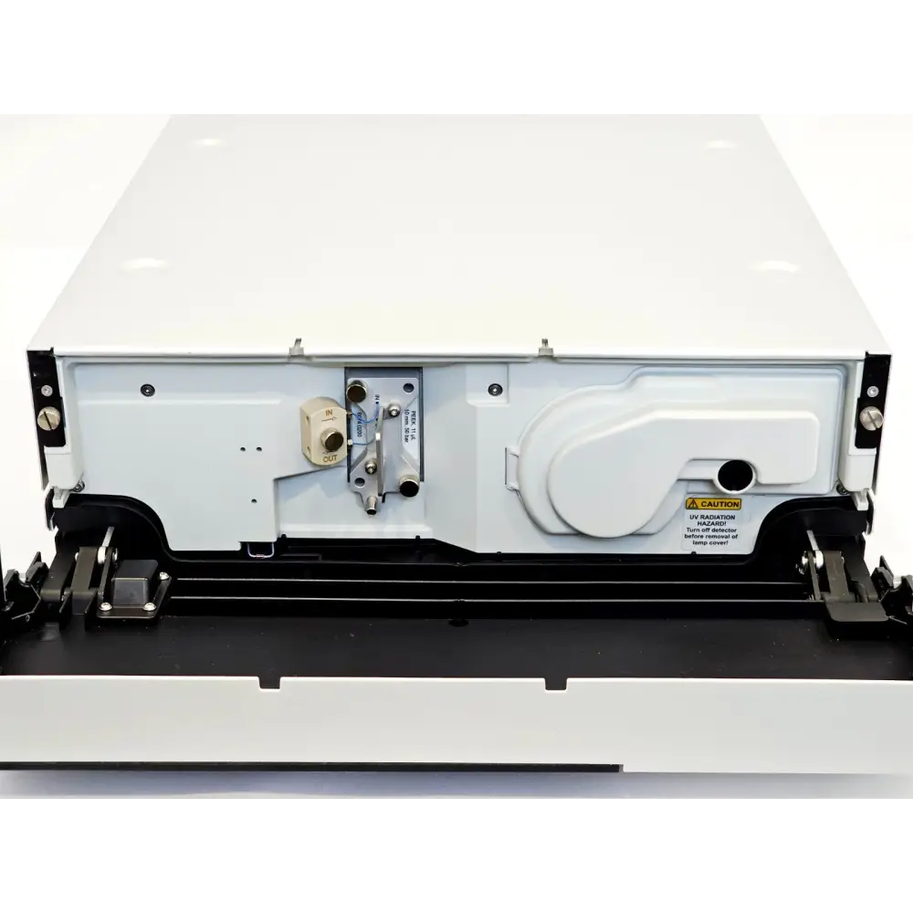 Dionex VWD-3400RS interior view showing PEEK flow cell inlet/outlet block and UV lamp housing compartment