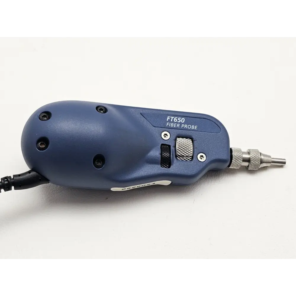 Fluke Networks FT650 Fiber Probe close-up showing FT650 label, focus/magnification toggle switch, and knurled FC tip fitted