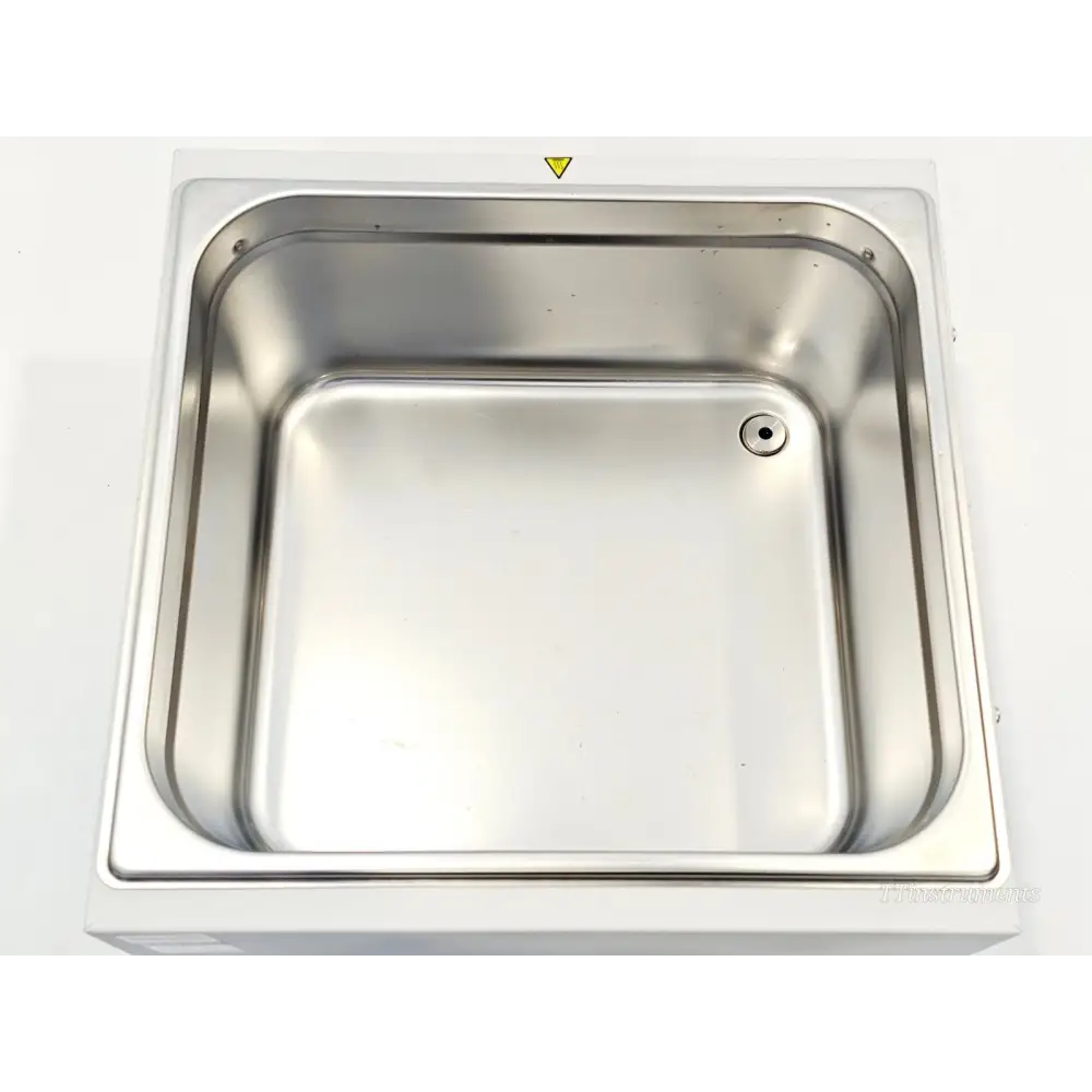 Grant Instruments JBN12 water bath top-down view of clean stainless steel tank interior with drain hole visible