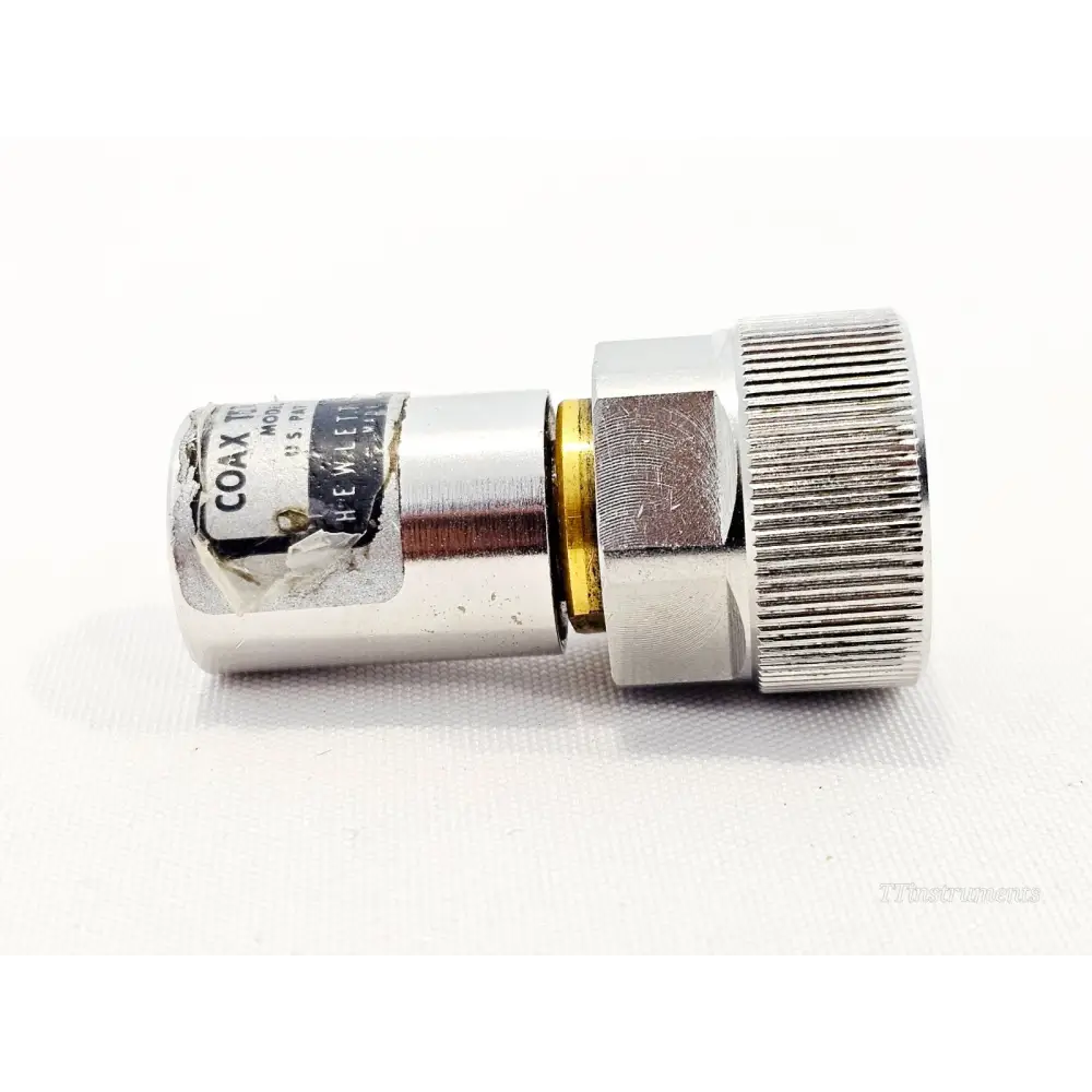 HP Agilent 909A APC-7 coaxial termination side angle view showing knurled body, gold collar, and worn HP identification label