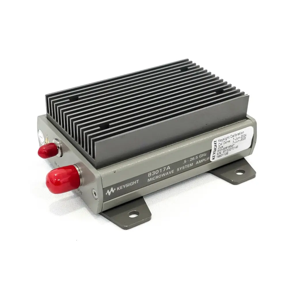 Keysight 83017A 0.5-26.5 GHz amplifier front-left angle showing calibration label, RF ports with red caps