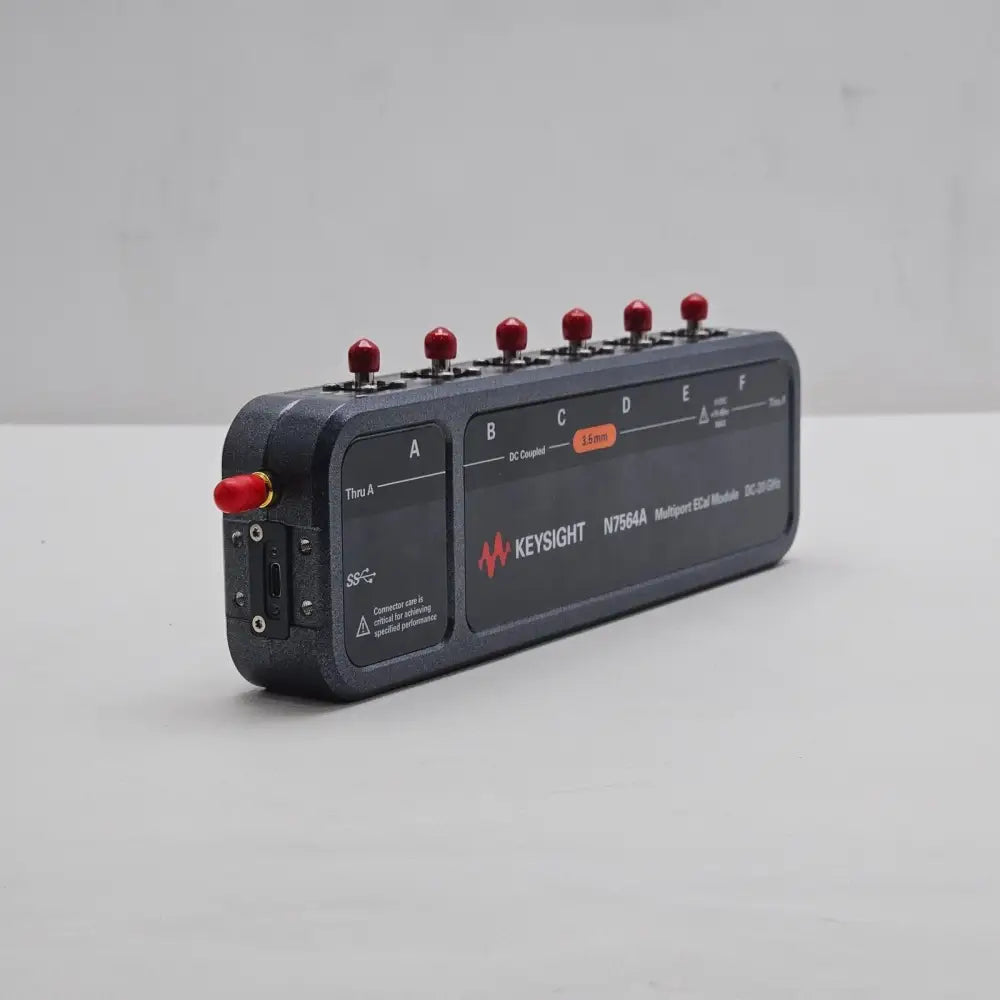 Keysight N7564A DC-20 GHz ECal Module angled front-right view showing ports A–F with red dust caps and USB connector