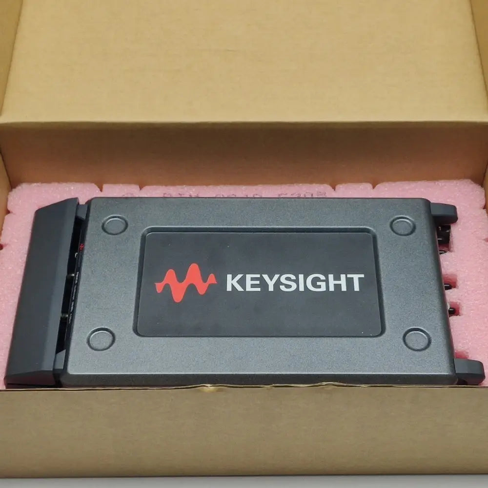 Keysight P9241A USB oscilloscope in open cardboard box with pink anti-static foam packaging, top view