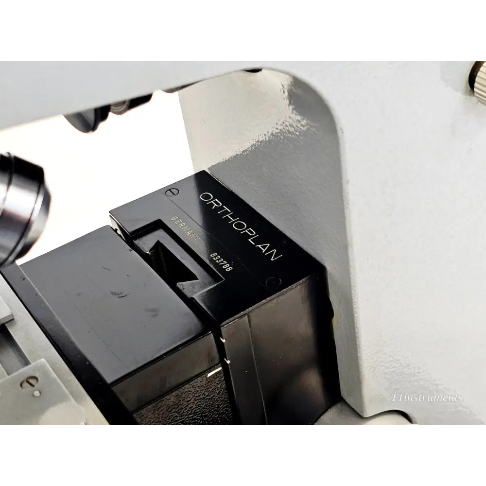 Close-up of Leitz Orthoplan model name plate engraved on black condenser housing showing serial number 833788, Germany