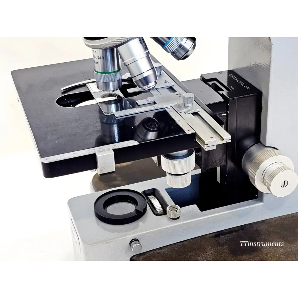 Leitz Orthoplan stage close-up showing NPL Fluotar objective, mechanical stage with verniers, sub-stage condenser and filter slot