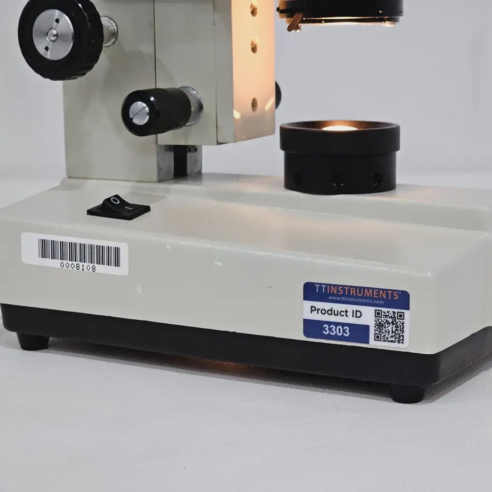 Side view of compound microscope displaying arm, coarse and fine focus controls and stage