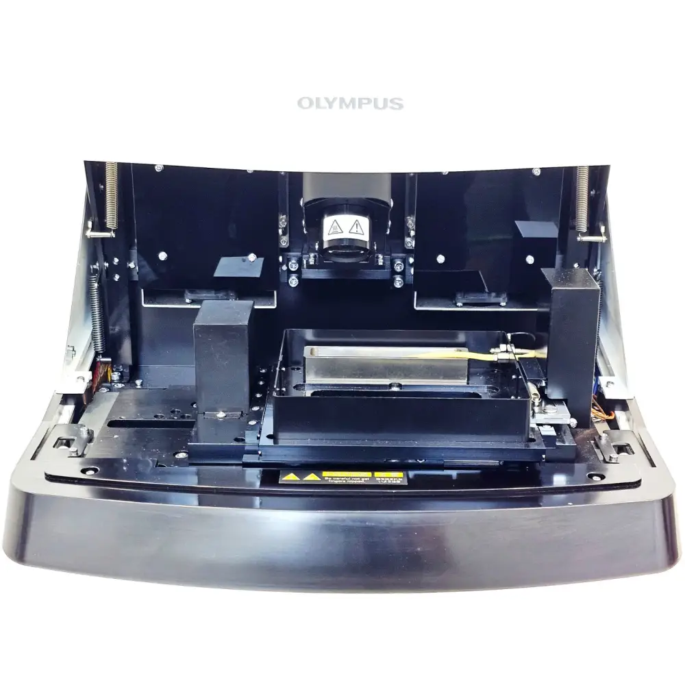 Olympus FV10i confocal microscope interior with lid open showing motorised XY stage, objective, and scan head