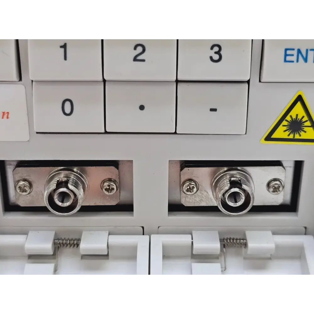 Santec OTF-930 close-up of front-panel FC/SPC OPT.IN and OPT.OUT optical connectors with laser warning
