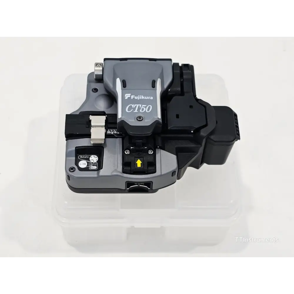 Fujikura CT-50 fibre cleaver top view on carry case showing blade arm, fibre clamp, Rotate/Link buttons and yellow scrap collector arrow