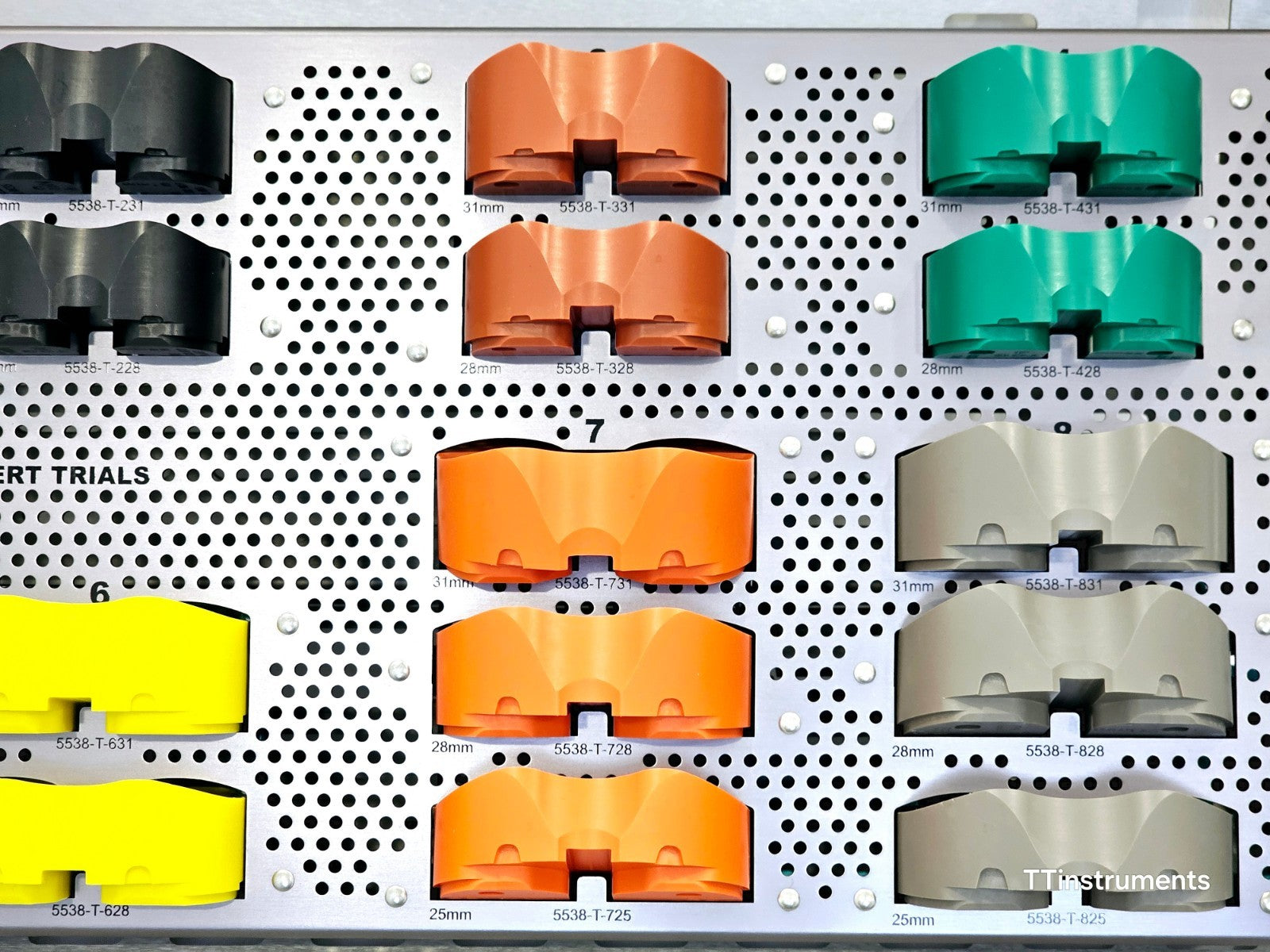 Close-up of Stryker Triathlon TCG inserts #3, #4, #7, #8 in copper, green, orange and grey with part numbers visible