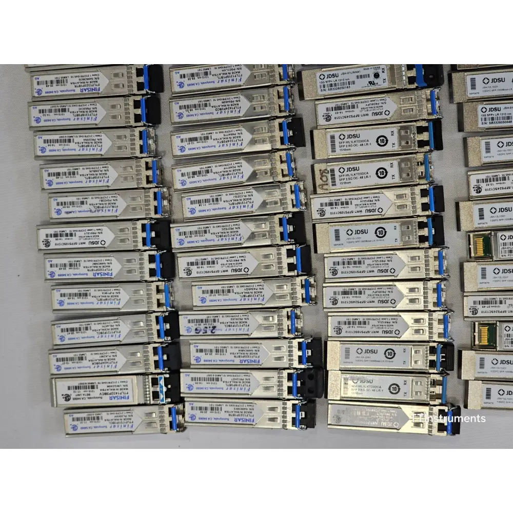 Close-up of assorted JDSU optical transceivers in untested job lot showing module labels