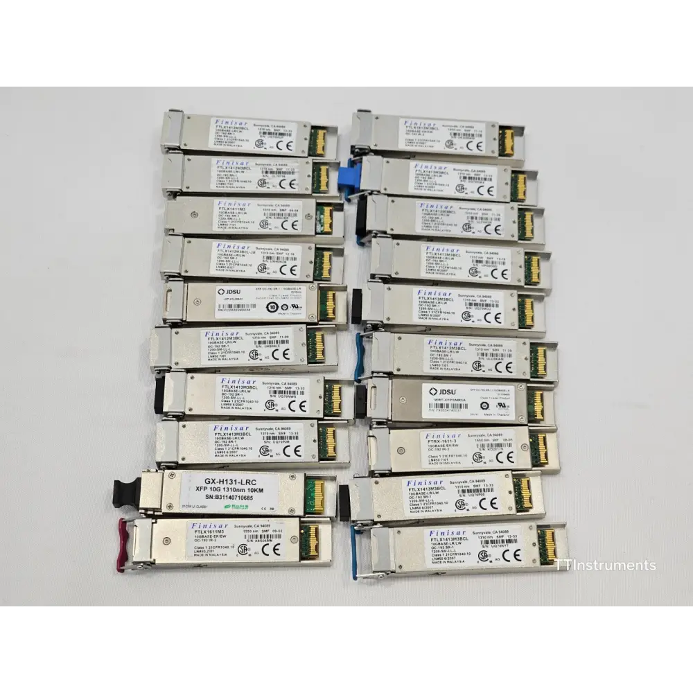 Close-up of assorted JDSU optical transceivers in untested job lot showing module labels